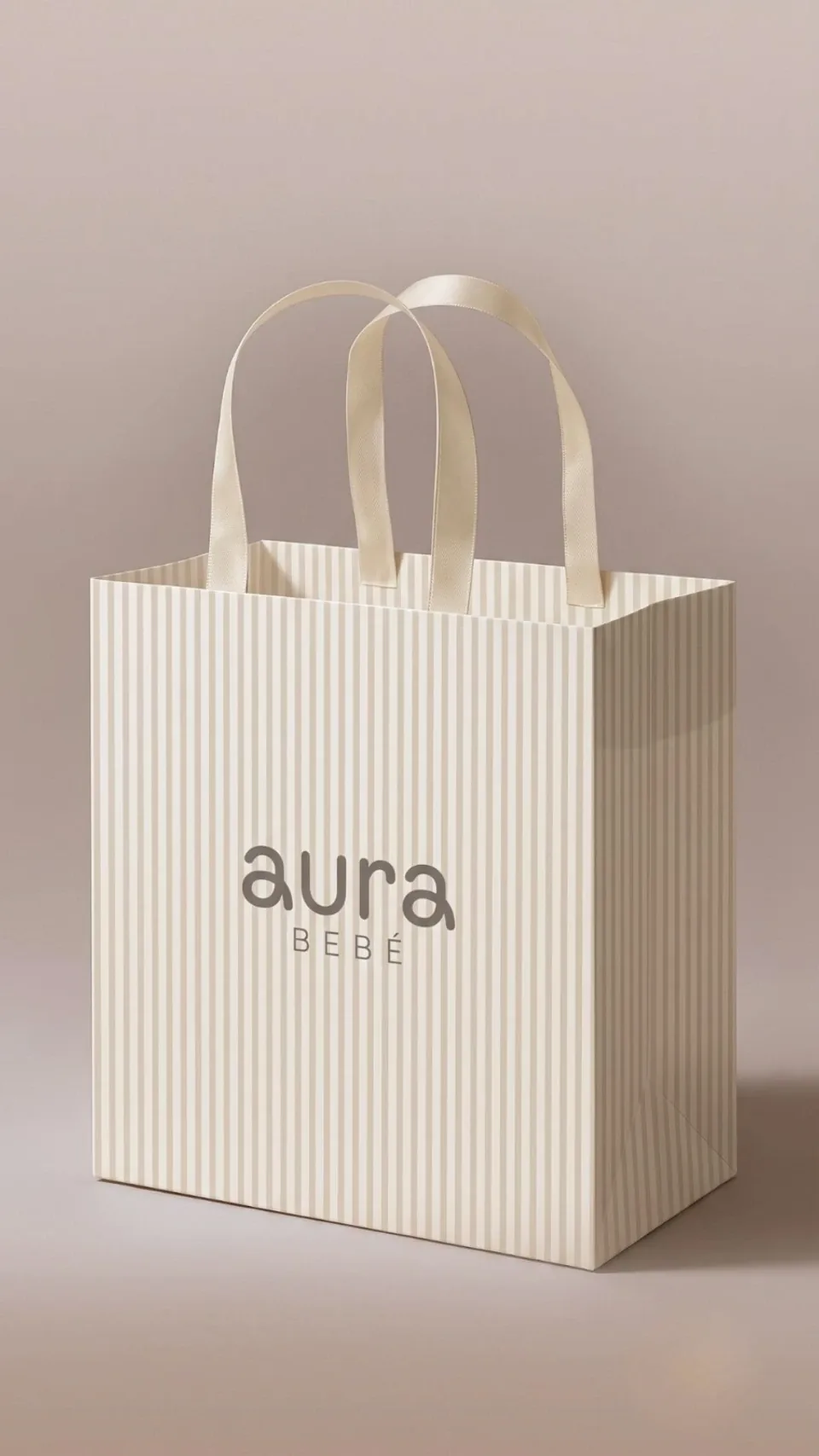 Bolsa de papel acanalado color crudo con el logotipo de Aura Bebé, en un fondo rosado