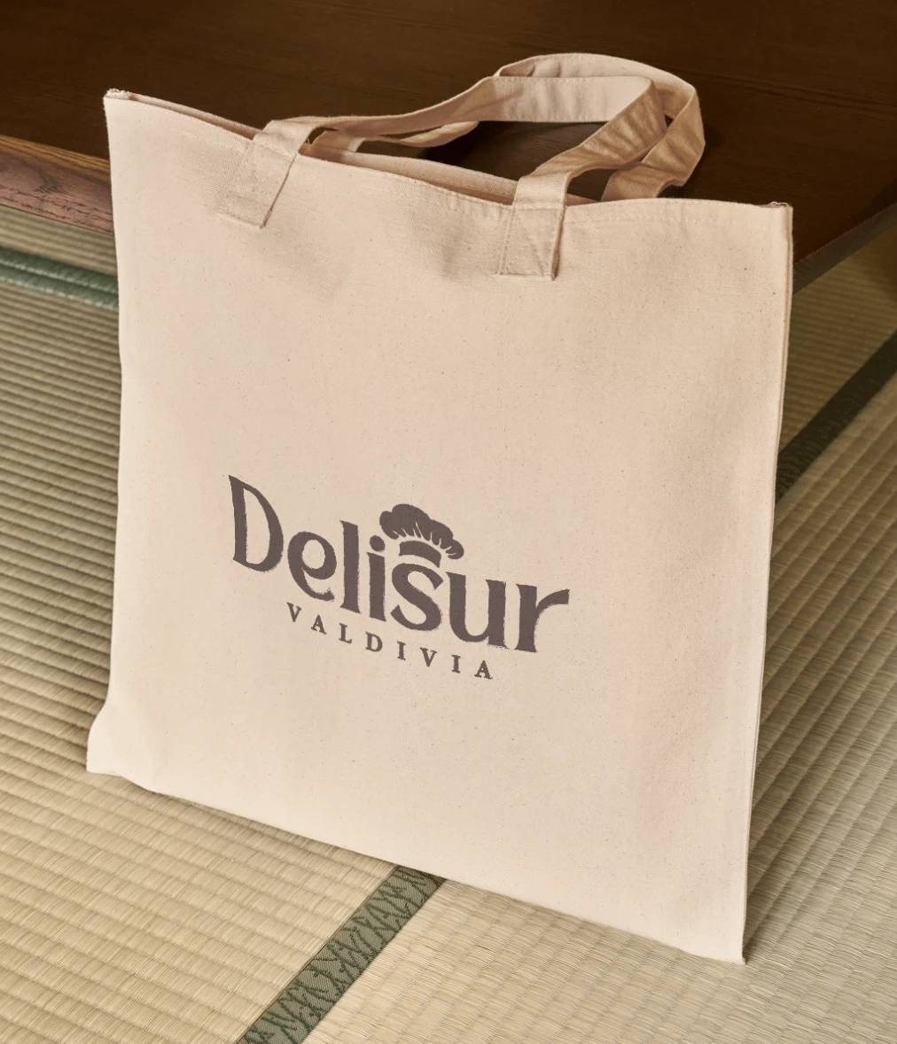 Bolsa de tela color crudo con el logotipo de Delisur Valdivia en café