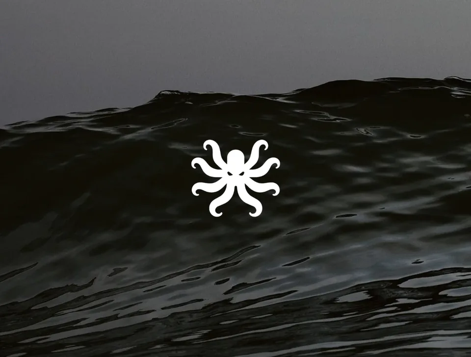 Isotipo del kraken en blanco sobre una fotografía de mar oscuro