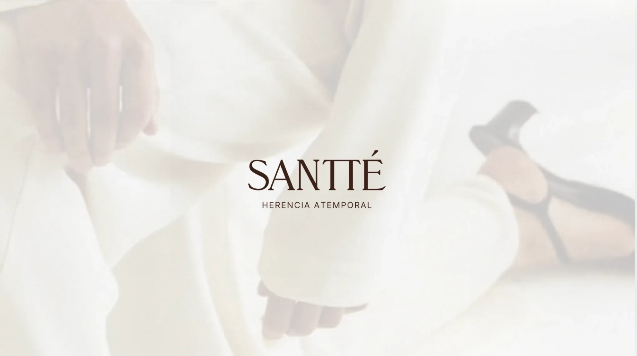 Logotipo de Santté Herencia Atemporal sobre una fotografía de prendas blancas