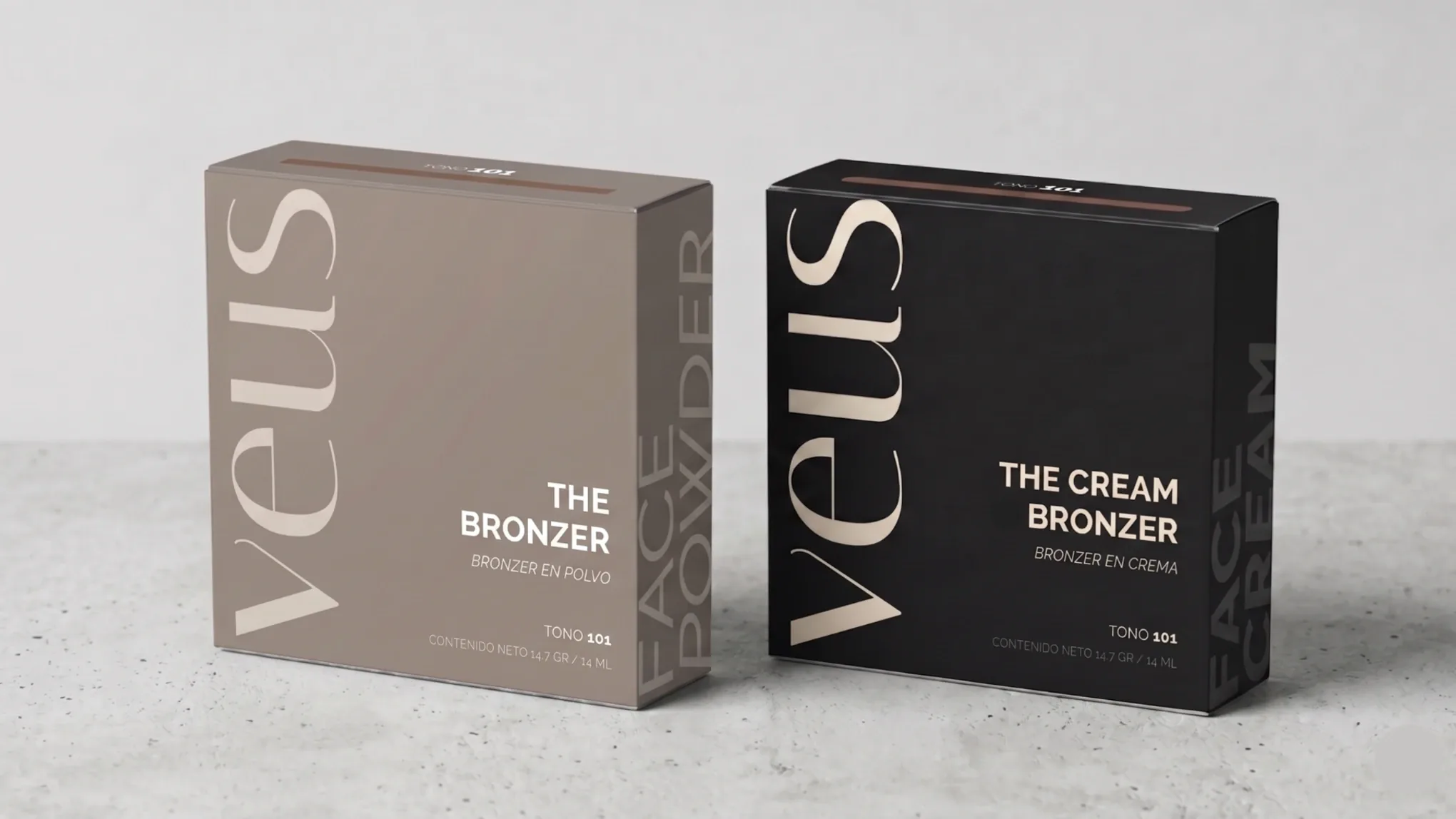 Las dos cajas de bronzer de Veus, una taupe y una negra, de pie sobre hormigón